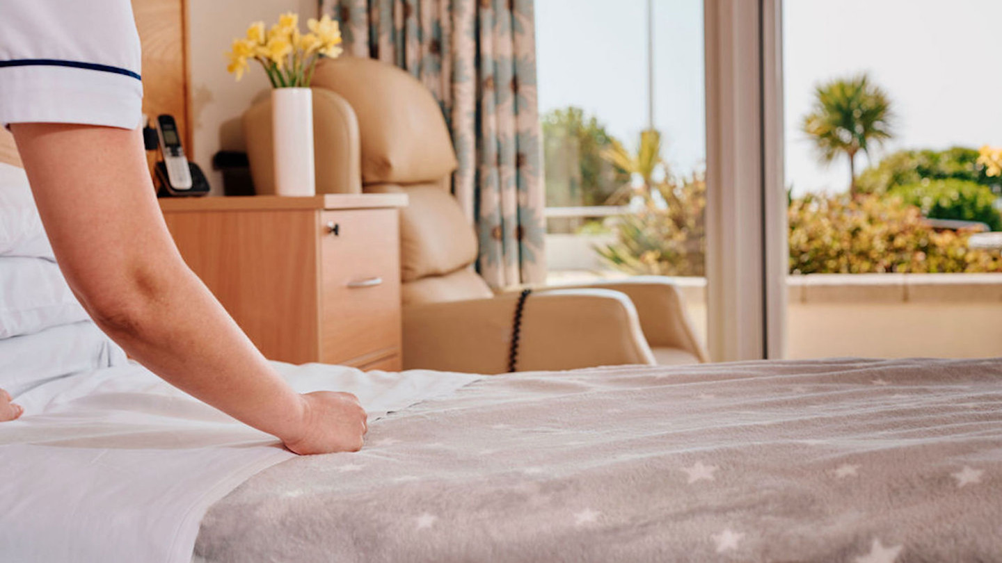 Image of Nurse making a bed in patient room