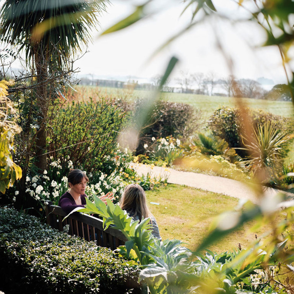 Image of Rev Emily in the gardens talking to patient 